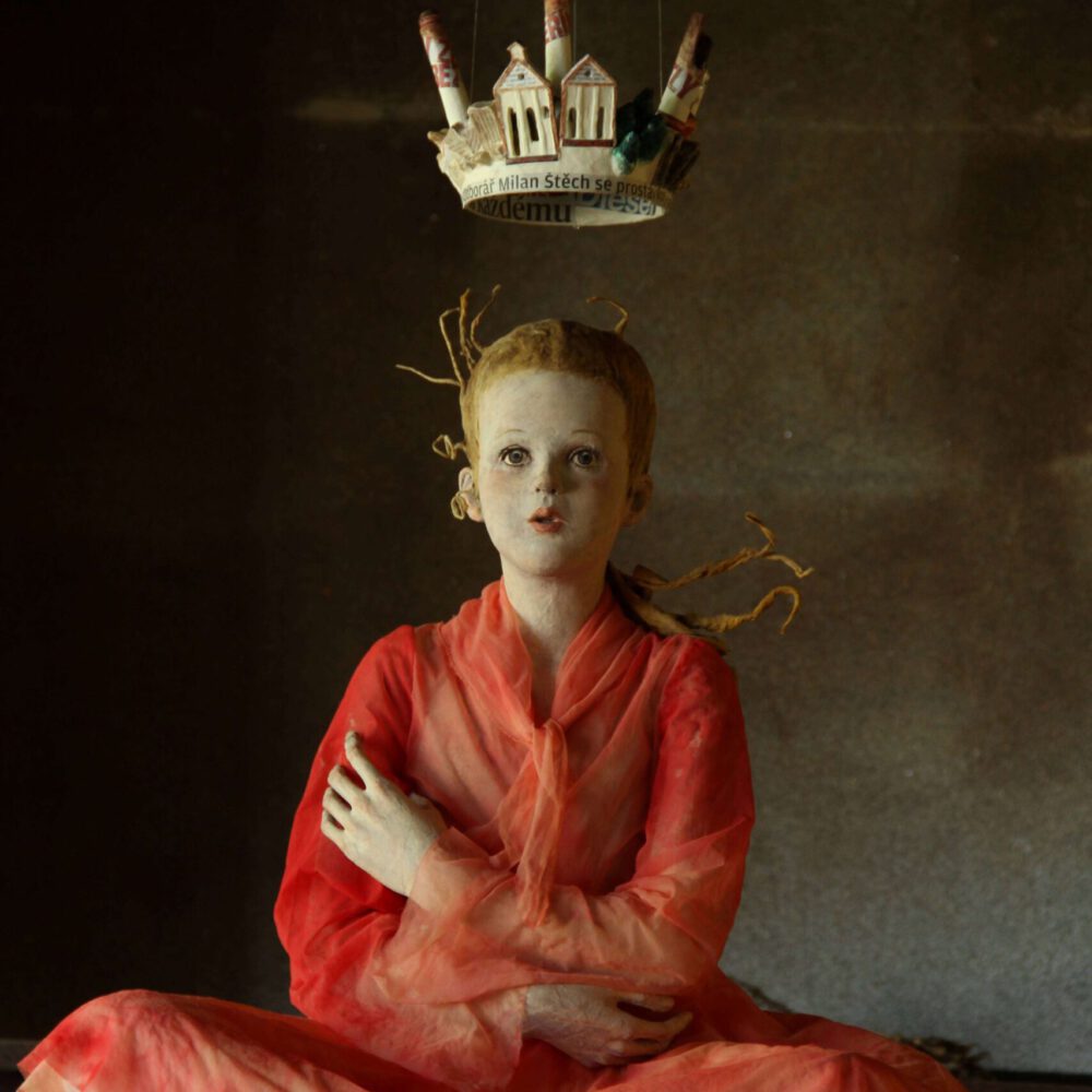 オレンジ色の服を着てすわる少女